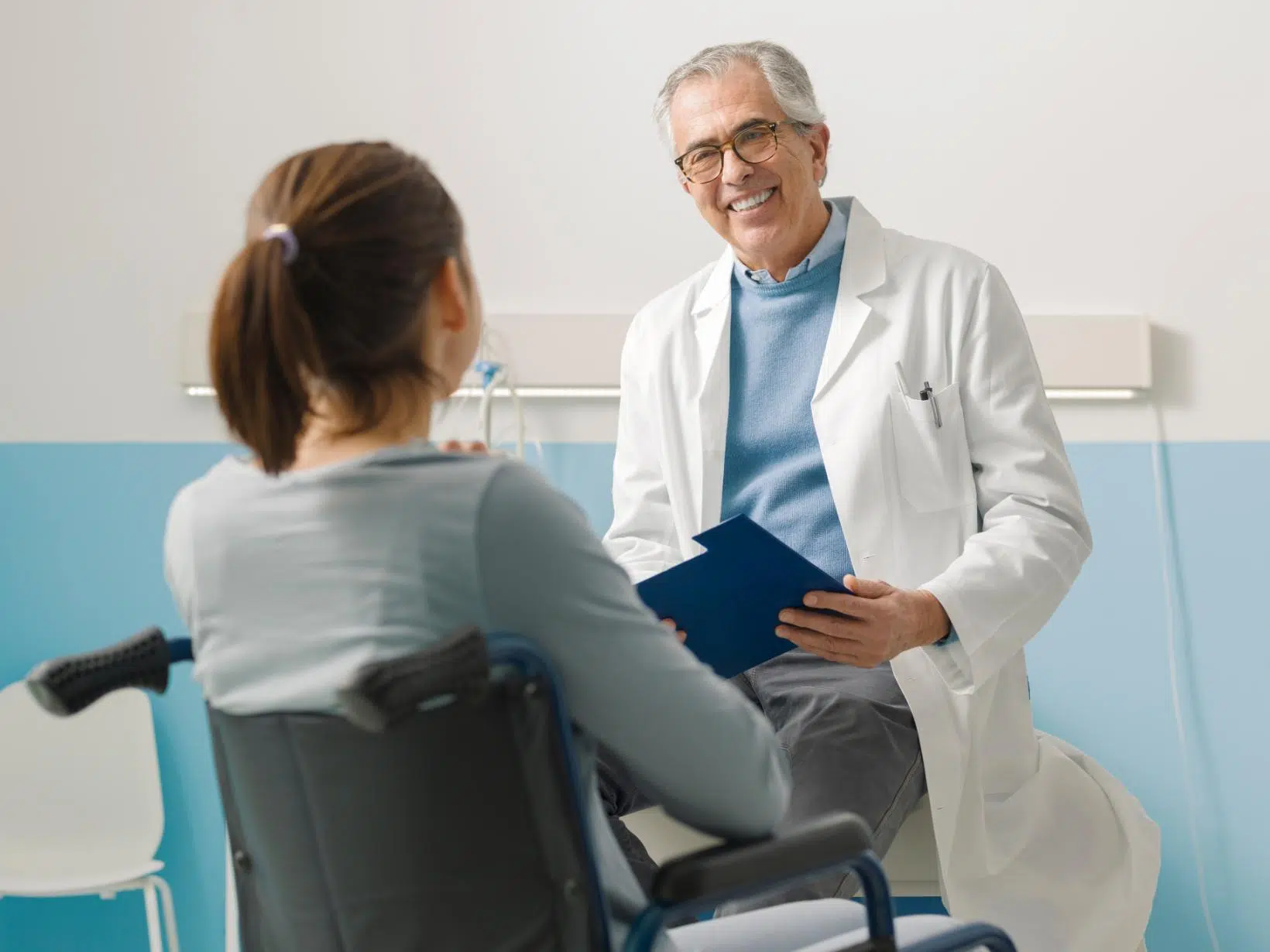 Paraplegie - impactul asupra calității vieții și abordări terapeutice moderne 3 - PrimaClinic.ro 5. Paraplegia - doctor care zâmbește, femeie în scaun cu rotile, cabinet medical
